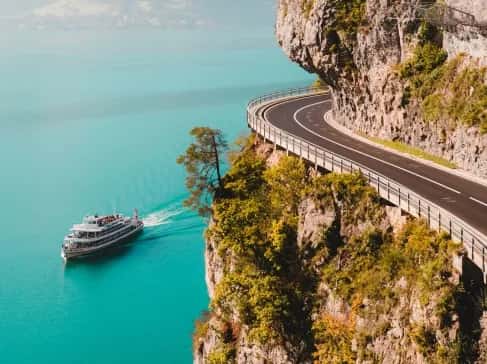 Loď na azurovém moři s útesem a silnicí
